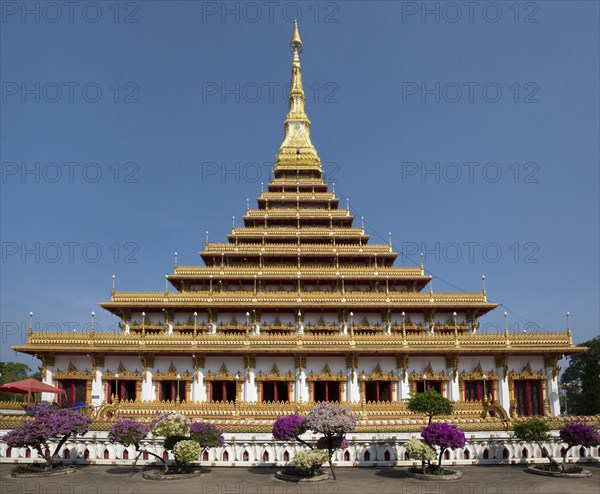 Flowering bushes in front of nine-story stupa Phra Mahathat Kaen Kakhon