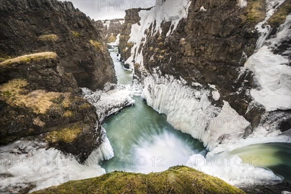 Partially icy waterfall in a canyon