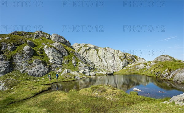 Two hikers at a small lake