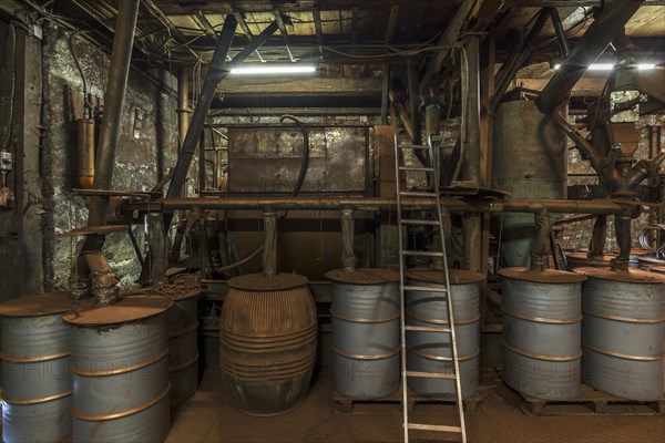 Production room for bronze powder with barrels and machines in a historical metal powder factory