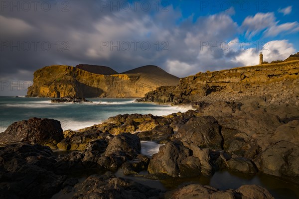 Rocky coast with lighthouse Farol da Ponta dos Capelinhos