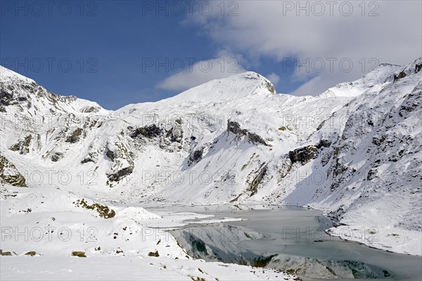 Nassfeld reservoir at 2233 m on the Grossglockner High Alpine Road with snowy mountains