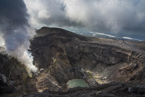 Steaming fumarole with crater lake on the Gorely volcano