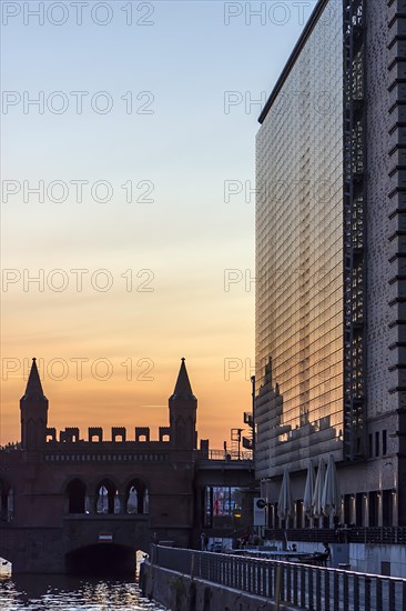 Modern skyscraper and Oberbaum bridge in the evening light