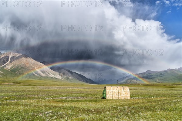 Tent under a rainbow over meadow