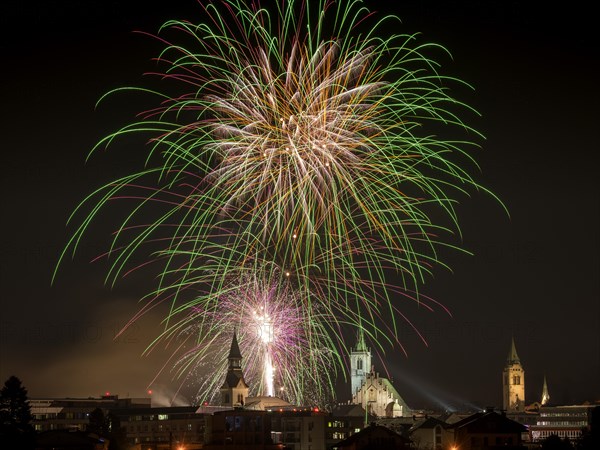 Fireworks over Schwaz on New Year's Eve with hospital church and parish church