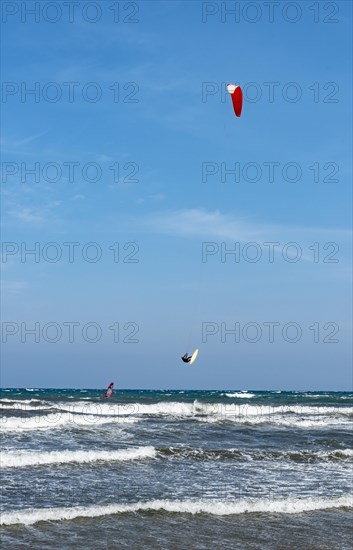 Kitesurfer in the air over sea with waves