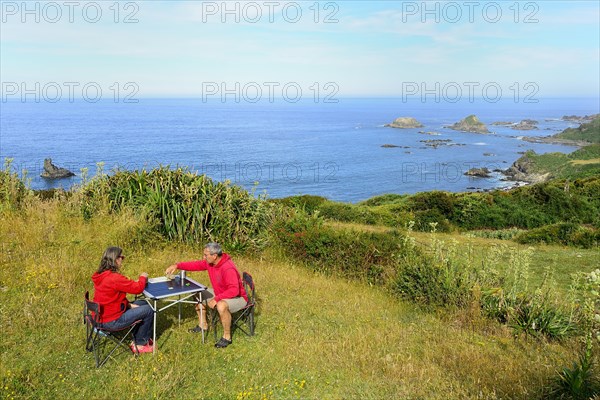 Couple plays board game on camping table