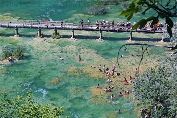 Tourists bathe at the waterfall Smotorcycleinski Buk