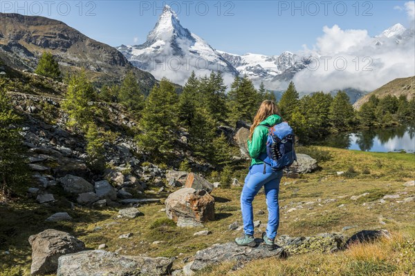 Hiker stands on rocks and looks into the distance