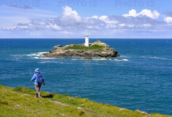 Woman hikes on coastal route at Godrevy Point