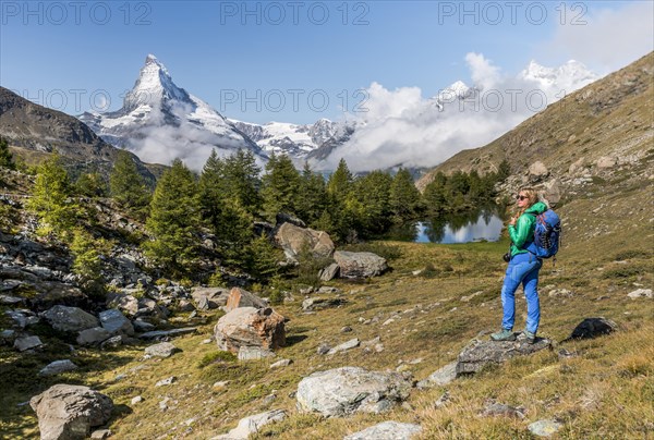 Hiker stands on rocks and looks into the distance