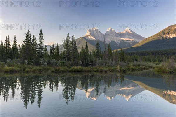 Three Sisters reflecting in calm water