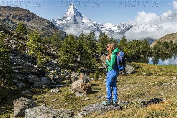 Hiker stands on rocks and looks into the distance