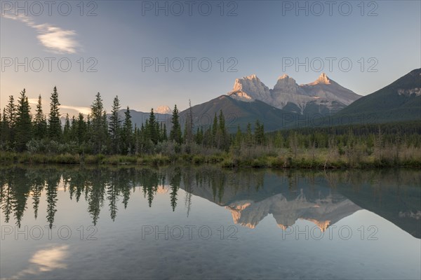 Three Sisters reflecting in calm water