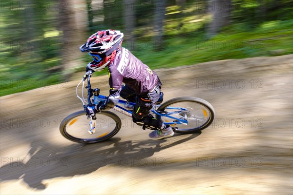 Child 9 years old rides on a mountain bike downhill