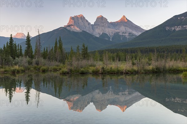 Three Sisters reflecting in calm water