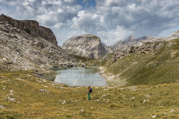 Hiker at the mountain lake Lech de Crespeina
