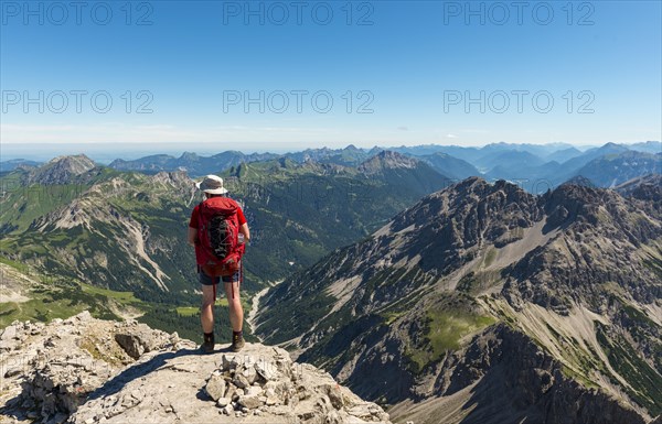 Hikers look out over mountains and alps