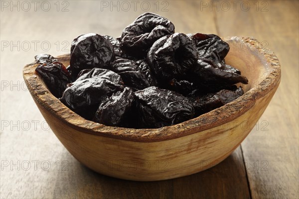 Dried Prunes in wooden bowl