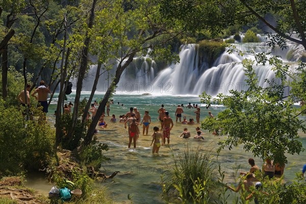 Tourists bathe at the waterfall Smotorcycleinski Buk