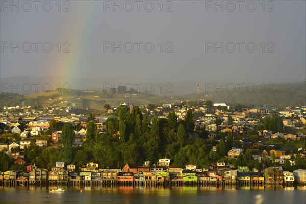 Rainbow over the city with stilt houses