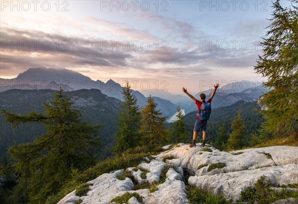 Hiker stretches his arms into the air