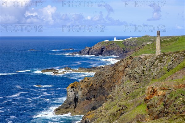 Rocky coast with old chimney from the Levant Mine and Pendeen Lighthouse