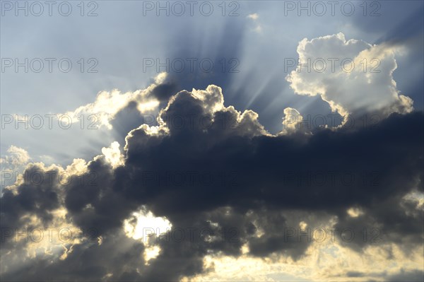 Sun shining behind dark clouds