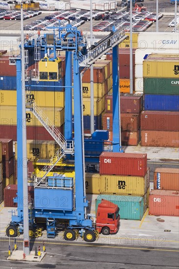 Top view of terminal with blue gantry crane loading truck with shipping container