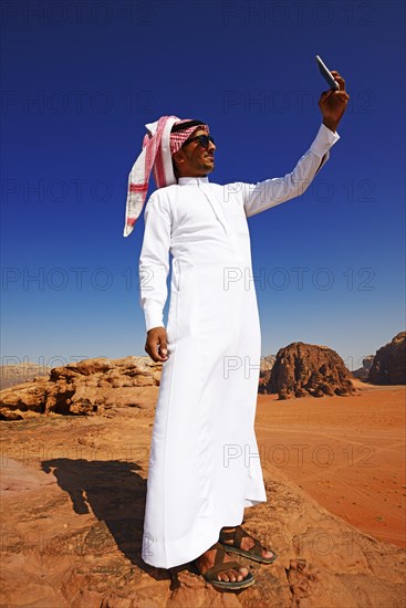 Bedouin uses his smartphone at Rock Arch