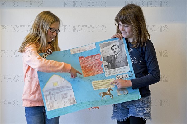 Two students with poster giving a presentation
