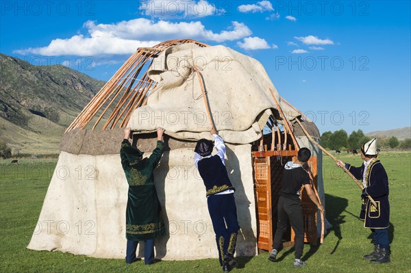 Kazakh men putting up a yurt