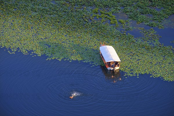 Boat and bathers in the river Rijeka Crnojevica