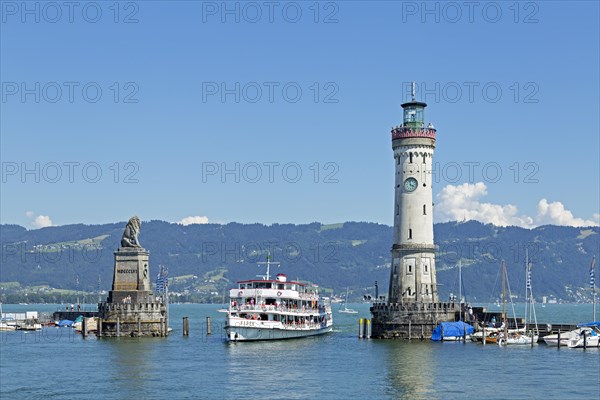 Passenger ship in port entrance with lighthouse in the harbor