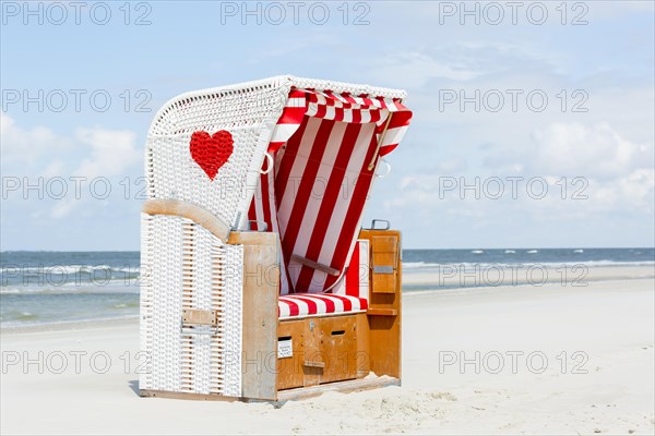 Beach chair with red heart on the beach