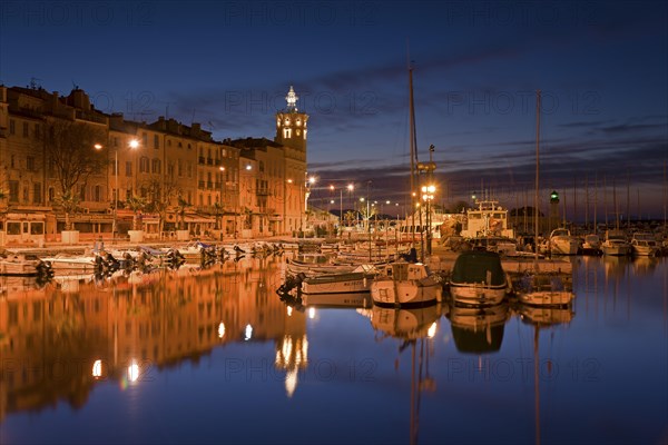 Old city with boats in the harbour at night