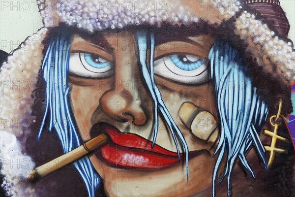 Face of a woman with cigarette and bandaid on cheek