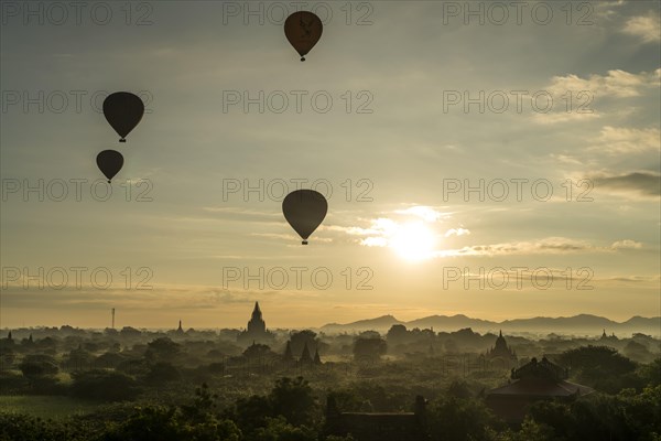 Hot air balloons at sunrise over temples and pagodas