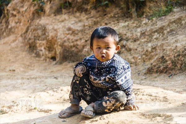 Little boy sitting on the ground