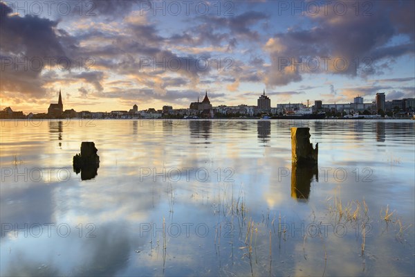 Old town and city harbour reflected in the river Warnow