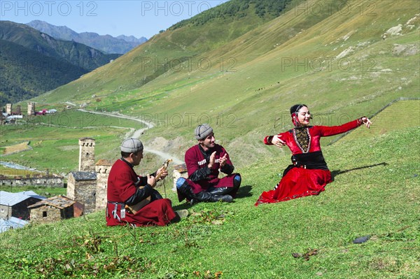 Georgian people of a folkloric group playing Panduri and dancing in traditional Georgian clothes