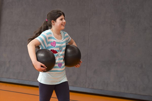 Schoolgirl playing ball in the gym