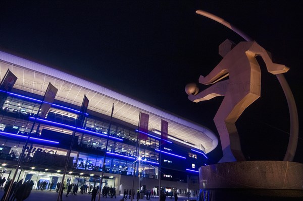 Sculpture of a soccer player in front of Wirsol Rhein-Neckar-Arena illuminated at night