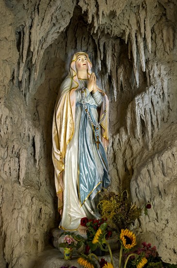 Lourdes grotto with a statue of the Virgin Mary