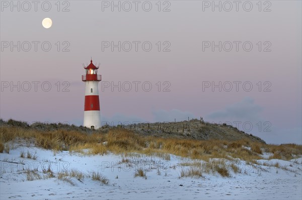 Red and white striped lighthouse List East in the dunes at the full moon
