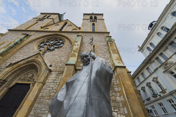Statue of Pope John Paul II in front of the Christian Sacred Heart Cathedral