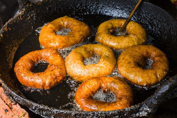 Doughnuts are fried in a pan with hot oil