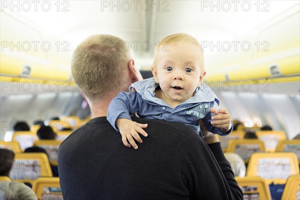 Father with his six months old baby boy in the airplane