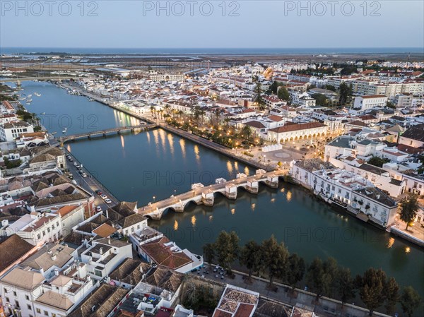 City view with roman bridge over Gilao river in old fishermen's town in the evening light